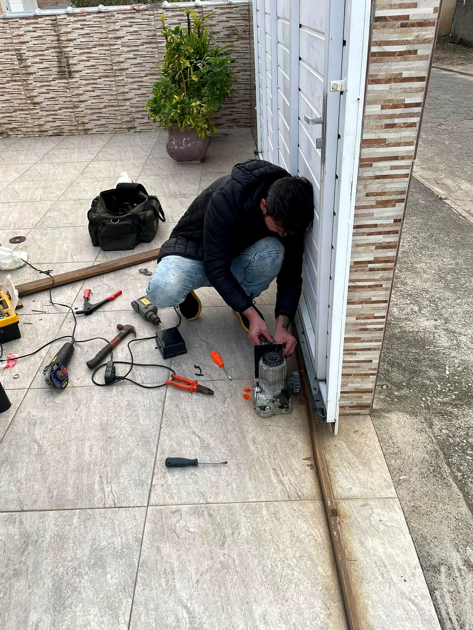 Técnico ajustando motor de portão automático